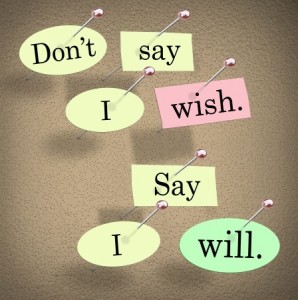 Colorful paper cutouts with text are pinned to a corkboard. The text reads, "Don't say I wish. Say I will." The background is a textured, light brown surface and the paper cutouts, in shades of green, yellow, and pink, are pinned with silver push pins—a motivational message ideal for the public sector.