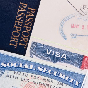 A close-up image of a dark blue passport, a visa document with various stamps, and a Social Security card arranged closely together highlights the significance of international relations. The visa document boasts several entry stamps, while part of the Social Security card number is partially visible.