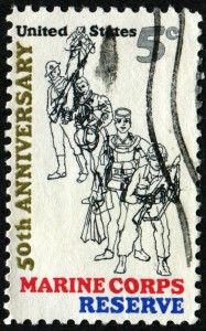 A postage stamp commemorating the 50th anniversary of the U.S. Marine Corps Reserve honors veterans by depicting four Marines in different uniforms and gear, spanning various eras. "United States" and "5¢" are at the top, with "Marine Corps Reserve" at the bottom.