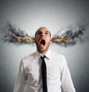 A man in a white shirt and black tie, perhaps overwhelmed by his career pressures, stands against a gray background, screaming with his mouth wide open. Animated flames and smoke appear to be coming out of his ears, creating a dramatic and surreal effect.
