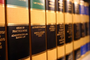 Close-up shot of legal books on a shelf. Book titles include "Areas of Practice Index: Administrative Law, Zoning Law" and "Alphabetical Index: Service Suppliers, Consumer Index," highlighting legal references and indexes with a focus on Federal Government regulations.