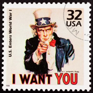 A U.S. postage stamp features Uncle Sam, a symbolic government figure of the United States, pointing directly at the viewer. Text reads "U.S. Enters World War I" on the left and "32 USA" on the top right. At the bottom, bold red text says "I WANT YOU." The stamp is dated 1998.