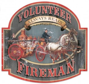 A vintage-style sign reads "Volunteer Fireman - Always Ready" featuring an old-fashioned fire engine with a horse pulling it and a firefighter riding on the engine. The weathered, distressed appearance adds to the nostalgic remembrance, evoking the bravery seen during 9-11.