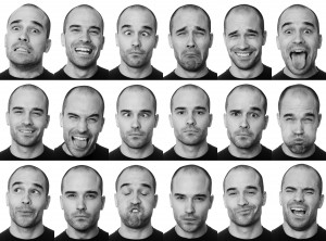 A black-and-white photo collage of a bald man wearing a black shirt, displaying 16 different facial expressions, including happy, sad, surprised, angry, confused, silly, and thoughtful. Each expression is captured in a distinct cell of the collage, showcasing the nuances of body language.