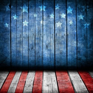 A rustic wooden backdrop painted to resemble an American flag, honoring our veterans. The top half features a blue background with white stars, mimicking the flag's canton, while the bottom half displays red and white stripes, symbolizing the flag's stripes.