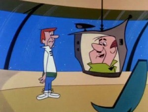 An animated man with orange hair, wearing a white sweater, stands on a futuristic spacecraft or building interior. He is looking at a screen that shows another animated man with a slightly larger face and green collar, appearing to communicate with him via telecommuting.