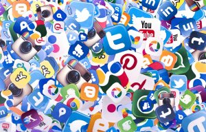 A chaotic collage of various social media logos, including Instagram, Twitter, Facebook, LinkedIn, YouTube, Pinterest, Google, and more, overlapping in a colorful and busy arrangement.