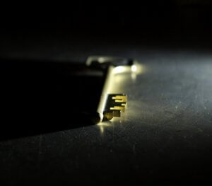 A golden key lies flat on a dark, reflective surface, partially illuminated by a soft light from the right, casting shadows that create a dramatic, mysterious atmosphere, suggesting a hidden vacancy waiting to be filled.