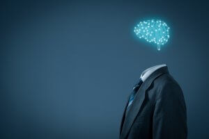 A person wearing a suit is depicted without a head, replaced by an illuminated, digital representation of a brain made up of circuitry. This symbolizes artificial intelligence and the integration of technology with human learning habits. The background is dark and minimalist.