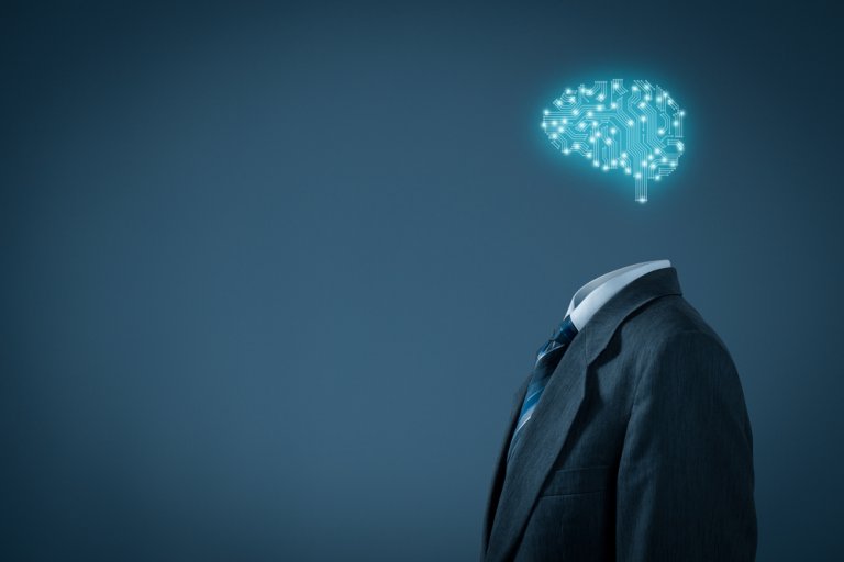 A person wearing a suit is depicted without a head, replaced by an illuminated, digital representation of a brain made up of circuitry. This symbolizes artificial intelligence and the integration of technology with human learning habits. The background is dark and minimalist.