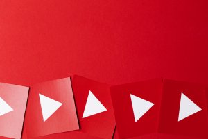 A row of red cards with white play icons, resembling the YouTube logo, lined up diagonally on a vibrant red background. The shapes are evenly spaced, creating a visually appealing and uniform pattern that is perfect for business presentations.