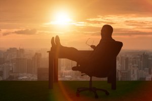 A person with notable career experience sits in a chair, feet casually propped up on the desk.