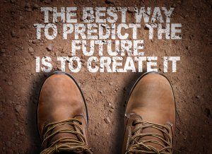 Image of two brown leather boots on a dirt surface with the following text above them: "THE BEST WAY TO PREDICT THE FUTURE IS TO CREATE IT." The words, in a white distressed font, invoke a sense of career experience, suggesting a motivational or inspirational message.