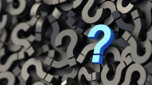 A blue question mark stands out prominently against a background of numerous black question marks of different sizes, creating a sense of curiosity similar to the intrigue sparked when someone says, "Tell me about yourself.