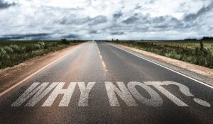 A long, empty road stretches into the distance under a cloudy sky. The words "WHY NOT?" are painted in large, bold white letters across the road’s surface, echoing the spirit of employee engagement and motivation.