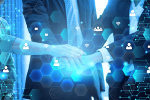 Three business professionals in suits place their hands together, signifying unity and teamwork. The image features a digital overlay of hexagonal patterns and icons related to technology and connectivity, such as Wi-Fi signals and user profiles, emphasizing engagement through collaboration.