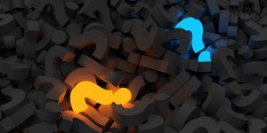 A pile of three-dimensional dark grey question marks, with one question mark glowing bright orange on the left side and another glowing blue on the right. The contrasting colors attract attention, symbolizing the clarity needed in effective governance amidst a sea of uncertainties.