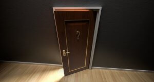 A slightly open wooden door with a question mark symbol on it, set against a dark wall, allowing a warm light to peek through the gap. The scene evokes a sense of career-related mystery and curiosity.