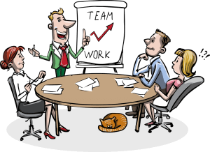 A cartoon image of four people in a meeting room sitting around a round table. One person is standing, making a presentation with an upward-trending graph on a board labeled "TEAM WORK." A ginger cat is curled up on the floor under the table, blissfully unaware of the problem-solving underway.
