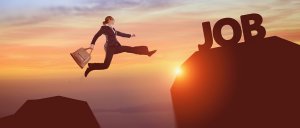 A person in business attire leaps across a gap between two cliffs, carrying a briefcase. The cliff they are jumping to has the word "JOB" on it, symbolizing achieving employment. The image is set against a sunset backdrop, mirroring the promise of new beginnings much like updating your resume template can.