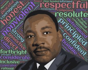 A portrait of Martin Luther King Jr. in the center, surrounded by multicolored words like "honest," "respectful," "confident," "nonviolent," and "resolute." Leadership shines through as the background is filled with these positive attributes in various fonts and colors.