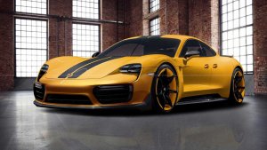 A sleek, modern yellow electric sports car with black racing stripes is displayed in a spacious, industrial-style room. The car features aerodynamic lines, large wheels, and a glossy finish, reflecting the light from the large windows and brick walls surrounding it.