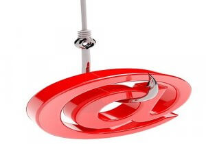 Image of a large, red at symbol (@) hanging on a fishhook, symbolizing phishing in cyber security. The fishhook appears metallic and sharp, penetrating the at symbol from the top. The background is plain white.