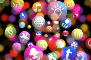A colorful array of floating spheres with various white icons, including a lightbulb, musical note, globe, wrench, shopping cart, LinkedIn symbol, and social media symbols among others, against a vibrant abstract background.