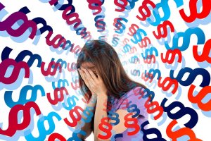 A person with long hair covers their face with their hands, appearing distressed. They are surrounded by a swirling pattern of variously colored section symbols (§) in red and blue, creating a chaotic and overwhelming workplace atmosphere.