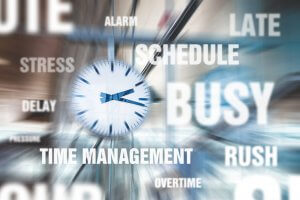 A blurred clock at the center with words like "TIME MANAGEMENT," "BUSY," "SCHEDULE," "STRESS," "ALARM," "LATE," "DELAY," "OVERTIME," "PRESSURE," and "RUSH" surrounding it, symbolizing the hectic nature of balancing time and knowledge in today's fast-paced world.