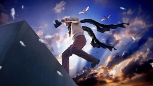 A person in motion, wearing a scarf and holding a camera, appears to run up a steep incline against a dramatic sky at sunset. Birds fly nearby, and feathers float in the air, creating a surreal and dynamic scene that feels worlds away from the monotony of an office.