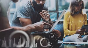 Three people are using electronic devices in an office setting, with abstract graphs, charts, and digital interface elements overlaid on the image. The atmosphere suggests a collaborative work environment focused on data analysis, technology, and networking.
