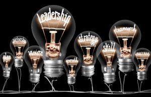 A group of light bulbs against a black background with their filaments forming words such as "leadership," "strategy," "teamwork," "defensive skill," "success," "growth," "vision," "plan," and "partnership," symbolizing key concepts in business and personal development.