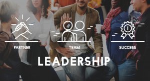 A group of diverse individuals engaged in conversation and holding coffee cups. The words "LEADERSHIP" appear at the bottom, with illustrations above representing "PARTNER," "TEAM," and "SUCCESS." The atmosphere conveys collaboration, teamwork, and the promise of rewarding careers in government.