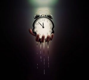 A hand holds a classic alarm clock, which appears to be melting and dripping like liquid. The image has a dark background, with the clock and drips illuminated, creating a surreal and dreamlike scene that symbolizes the fluid nature of time in Government Jobs.