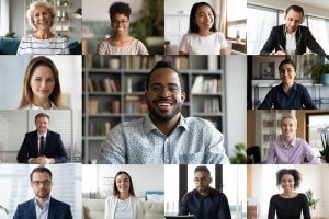 A virtual meeting interface shows fifteen diverse people in individual video frames, smiling at their cameras. The background varies from bookshelves to office settings, depicting a remote video conference setting ideal for discussing careers in government.