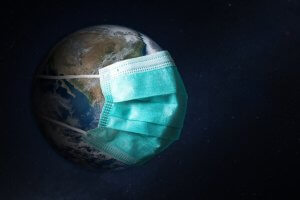 A representation of the Earth in space is shown wearing a blue medical mask, symbolizing global health and the impact of the COVID-19 pandemic. The dark background signifies the universe surrounding the planet, much like how Government Jobs are vital for ensuring public well-being and safety on a larger scale.