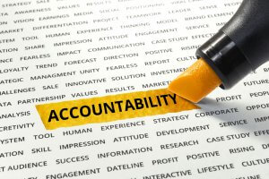 A yellow highlighter marks the word "ACCOUNTABILITY" on a page filled with various business-related terms. The highlighted word stands out among the other black-printed words, emphasizing its importance, particularly in careers in government where accountability is essential.