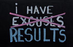 A blackboard with the phrase "I have excuses" written in white chalk, where "excuses" is crossed out with a pink line, and the word "results" is written below it in blue chalk. This emphasizes a motivational message about prioritizing results over excuses, especially relevant for those pursuing careers in government.