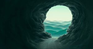 A view from inside a dark cave looking out at a serene landscape of rolling green hills under a pale sky. The cave's jagged rocky walls frame the softly lit outside scene, creating a contrast between the dark interior and the light, calm exterior—dispelling any assumptions of what lies within.