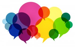 Colorful overlapping speech bubbles of varying sizes in shades of red, pink, orange, yellow, green, blue, and purple create a vibrant and lively visual representation of communication and conversation at work.