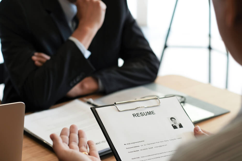 Examiner,Reading,A,Resume,During,Job,Interview,At,Office,Business