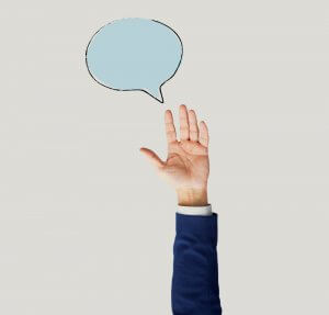 A person wearing a blue suit raises their right hand with fingers extended against an off-white background. A light blue speech bubble with quotes is drawn above their hand.