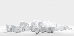 A pile of 3D white question marks on a white surface with a light gray background. The question marks are scattered and overlapping, which could lead to a sense of confusion or inquiry.