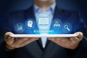 A person in a suit is holding a tablet with icons floating above it, representing different aspects of e-learning such as a book, head with gears, pie chart, video call, and magnifying glass. The word "eLearning" is prominently displayed in the center.