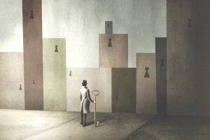 A surreal artwork depicting a person in a coat and top hat holding a large key, standing in front of tall wall structures with oversized keyholes. The landscape is muted with shades of grey and brown, giving a mysterious, dreamlike atmosphere that mirrors the enigmas of life.