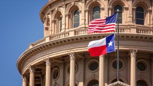 The American and Texas state flags wave in front of the Texas State Capitol's domed building, featuring arched windows and Corinthian columns, under a clear blue sky—a symbol of pride for every local job holder contributing to the state's growth.