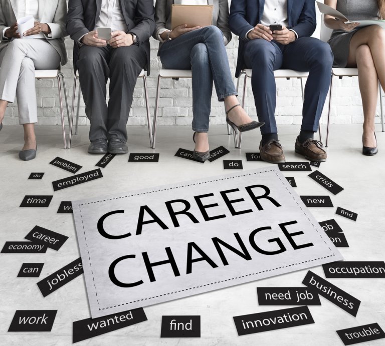 Five people sit on chairs holding electronic devices, their legs visible. A large sign in front of them reads "CAREER CHANGE." Surrounding the sign are scattered smaller words like "economy," "crisis," "career," "jobless," "innovation," and "employed.
