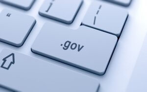 A close-up view of a light gray computer keyboard showing a key labeled ".gov," indicating government-related websites. The keyboard button is centered and prominently displayed, with surrounding keys slightly visible in soft focus—a crucial tool for navigating governments' digital resources.
