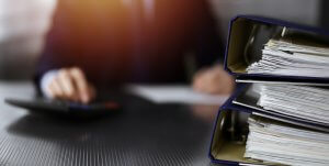 A man signing some documents in the background